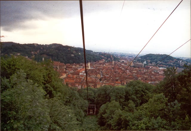 Brașov old town seen from the slopes of Tâmpa, red roofs below the hills